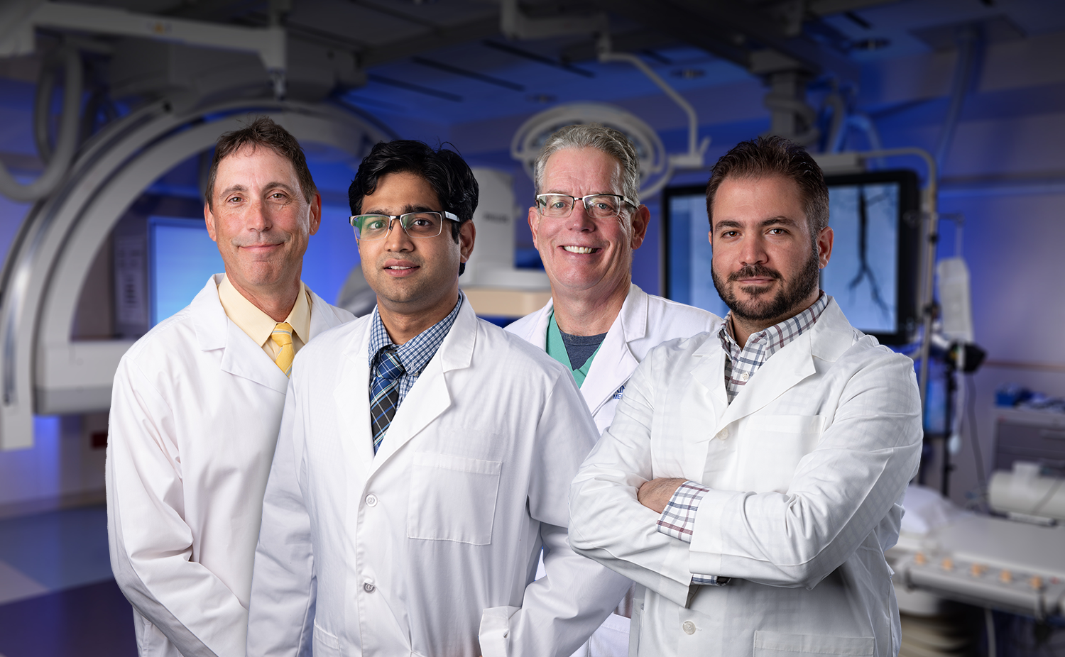 Four men in white lab coats